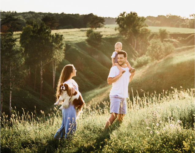 A photo of a family walking near woods.